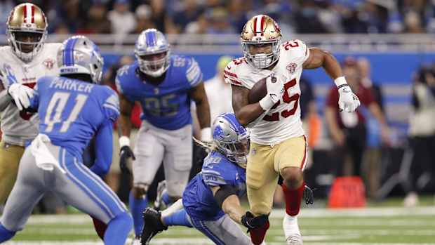 Sep 12, 2021; Detroit, Michigan, USA; San Francisco 49ers running back Elijah Mitchell (25) runs past Detroit Lions middle linebacker Alex Anzalone (34) during the fourth quarter at Ford Field. Mandatory Credit: Raj Mehta-USA TODAY Sports